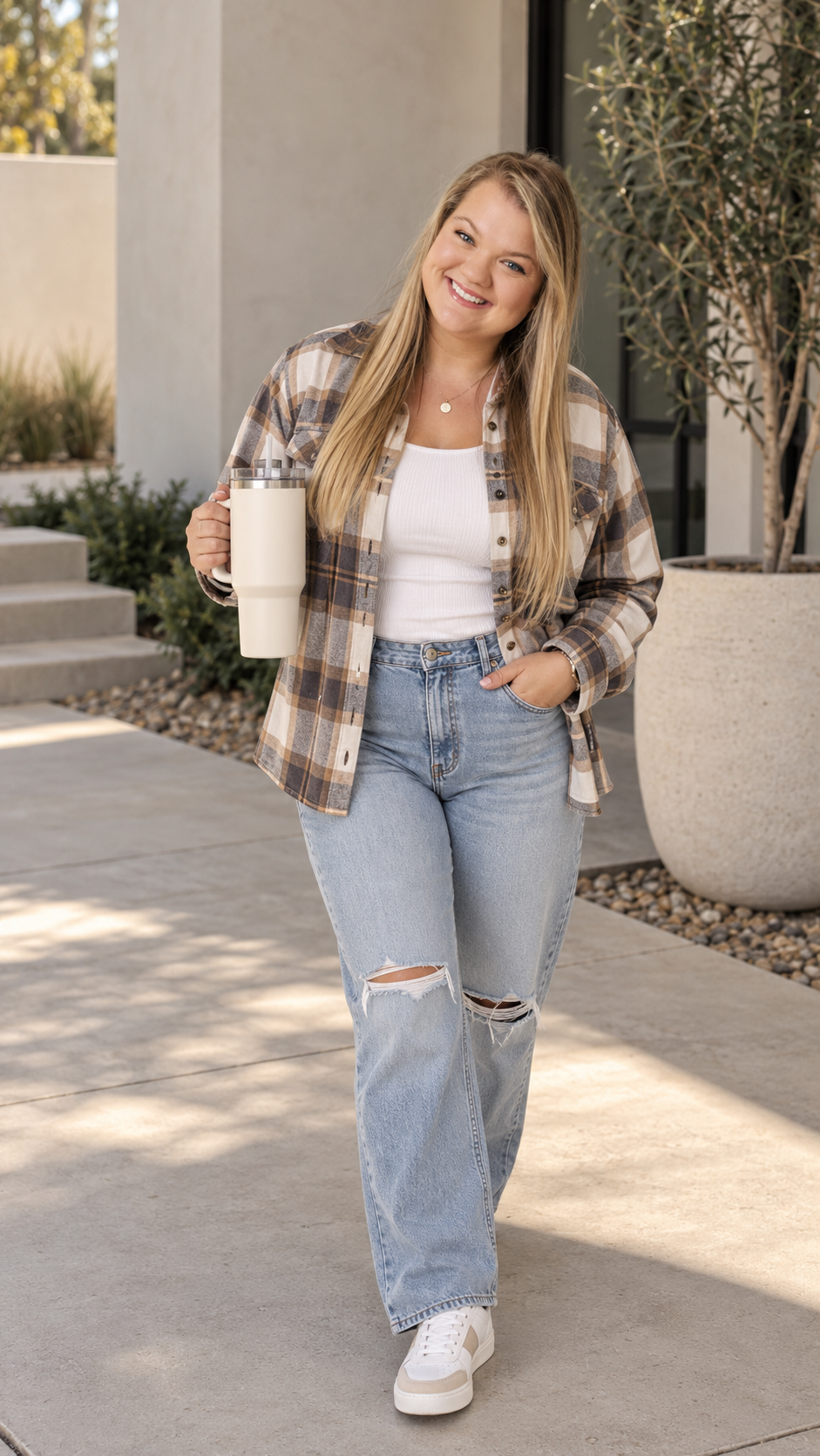 Kendyll walking outside in a fall plaid shirt, smiling